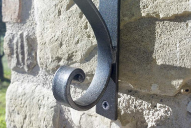 Detail of the curl of the hand-forged wrought iron outdoor wall lamp - For sale Tivoli by Artigianfer Spello Italy